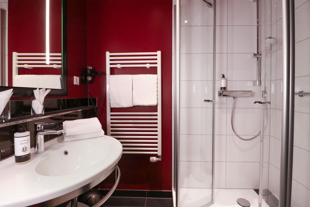 Badezimmer mit Waschbecken, Dusche und Handtuchheizung