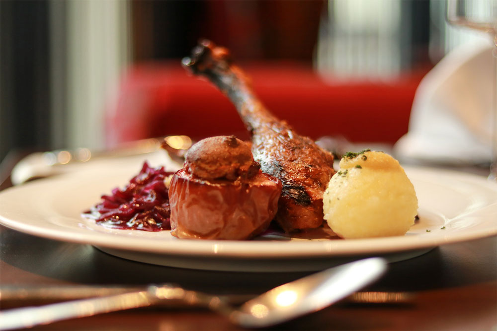 Gänsebraten mit Rotkohl, einem Kartoffelkloß und einem Bratapfel